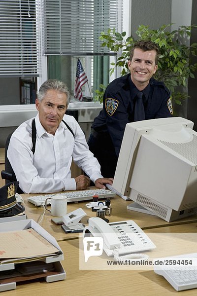Zwei Polizisten  die in einem Büro arbeiten.