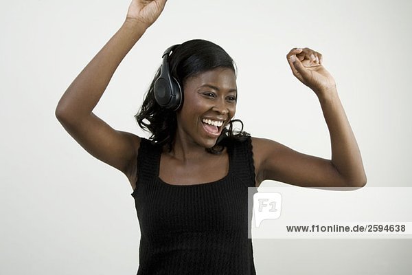 An African American woman wearing headphones and dancing  studio shot