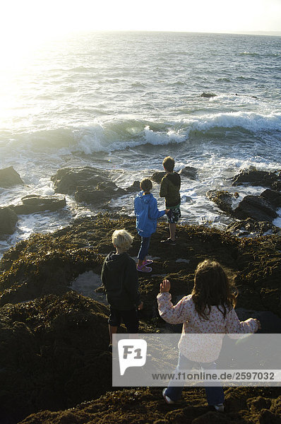 High angle view of four children standing at coast