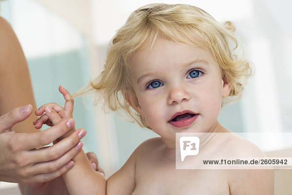 Baby (12-24 Monate) blond blauäugig hält Hand nur Baby Portrait