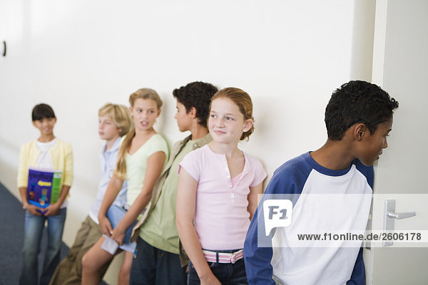 Multinationale Gruppe mit Schulkindern (10-13) warten vor Klassenraum