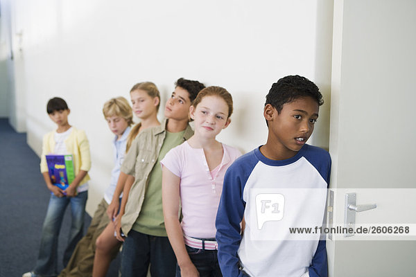 Multinationale Gruppe mit Schulkindern (10-13) warten vor Klassenraum