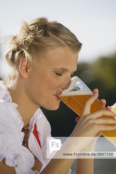 Junge Frau in Tracht trinkt Weizenbier Biergarten am Seehaus Englischer Garten Nahaufnahme Seitenansicht
