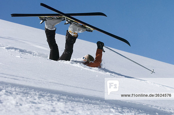 Gefallener Skifahrer im Pulverschnee liegend
