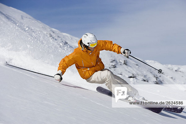 Skier carving through powder snow