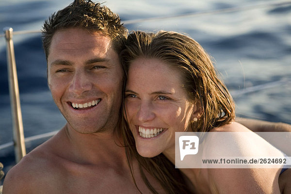 Paar lächelt auf dem Boot auf See