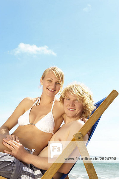 Young couple sharing a deck chair
