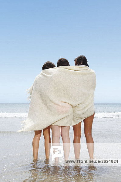 Drei Mädchen  die sich eine Decke teilen