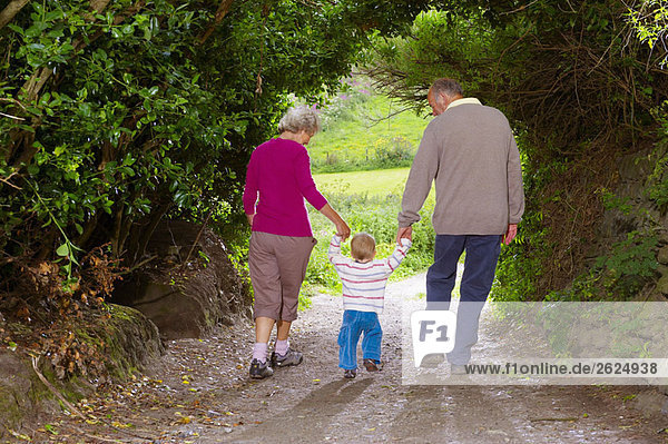 Seniorenpaar zu Fuß mit Kind