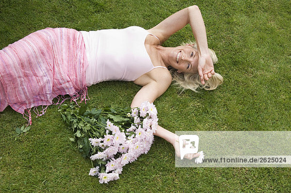 Entspannte Frau auf Gras liegend