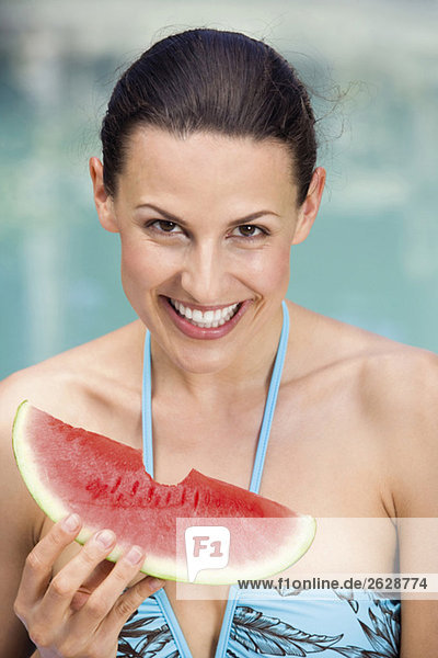 Junge Frau im Bikini mit Melone  Portrait  Nahaufnahme