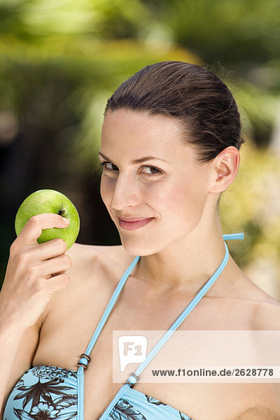 Junge Frau im Bikini mit Apfel  Portrait  Nahaufnahme
