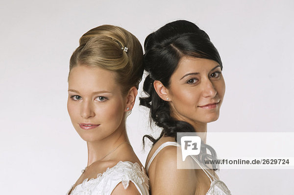 Young brides standing back to back  portrait