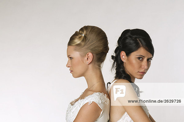 Young brides standing back to back  portrait