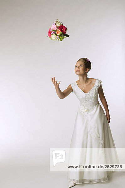 Young bride tossing bridal bouquet
