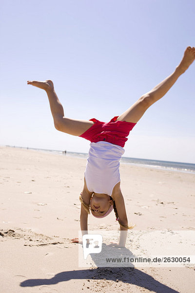 Germany  Baltic sea  Girl (6-7) doing handstand on beach