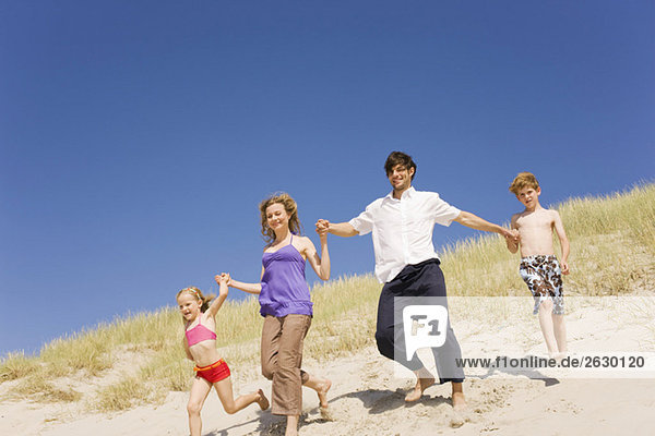 Germany  Baltic sea  Family running down beach dune
