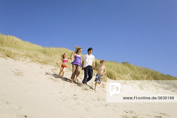 Germany  Baltic sea  Family running down sand dunes