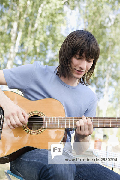 Junger Mann spielt Gitarre  Portrait