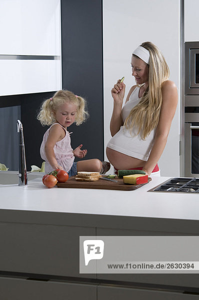 Schwangere Mutter und Tochter (3-4) in der Küche