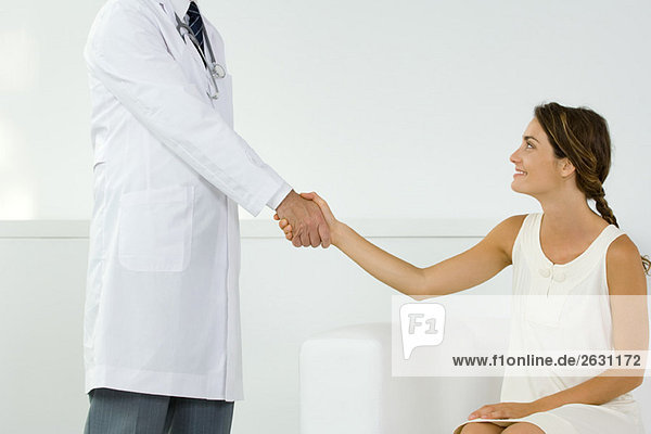 Woman shaking hands with doctor  cropped view