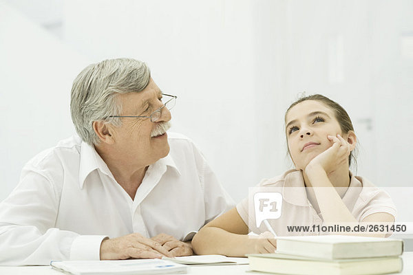 Grandfather helping granddaughter with homework