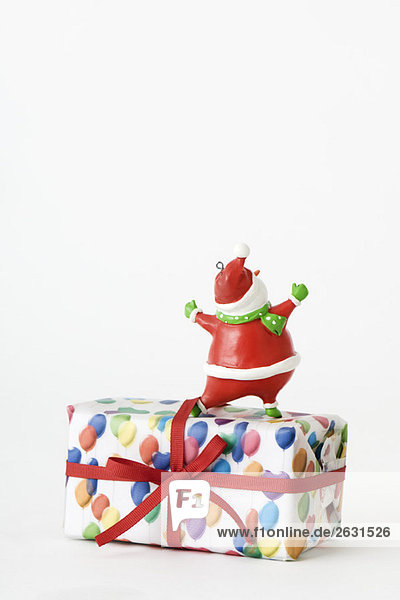 Santa Claus figurine standing on top of Christmas present  rear view