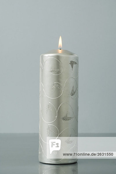Solitary silver advent candle  burning