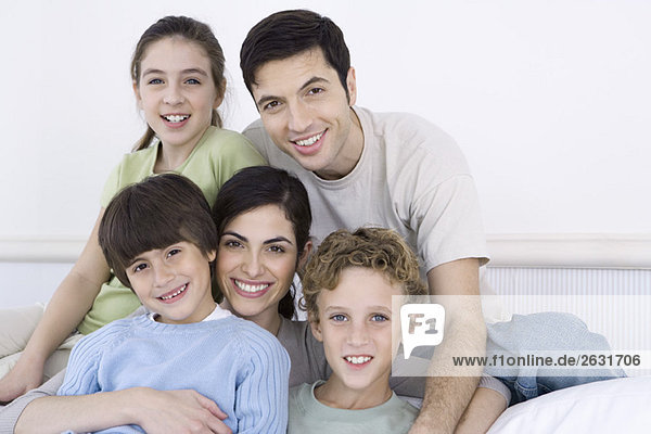 Eltern und drei Kinder lächeln vor der Kamera  Porträt