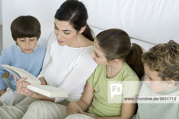 Frau liest ihren Kindern die Geschichte vor
