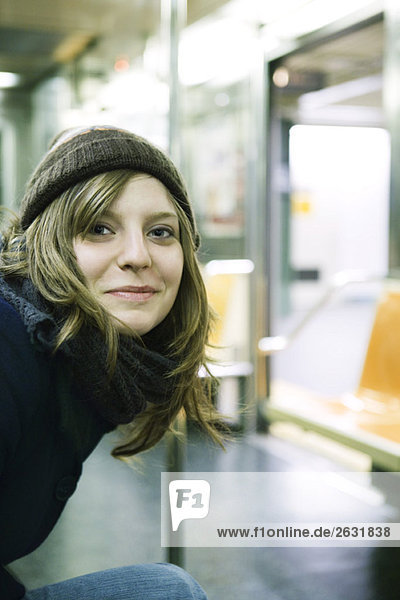 Junge Frau in der U-Bahn  lächelnd vor der Kamera