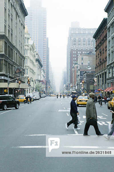 Fußgänger überqueren die Straße in der W 19th Street und 6th Avenue Chelsea  New York  mit Blick auf NE