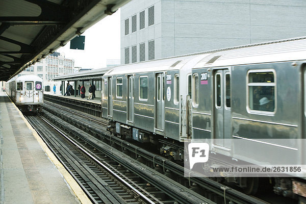 Pendler warten auf die U-Bahn auf dem erhöhten Bahnsteig  IRT Flushing Line of New York City Subway