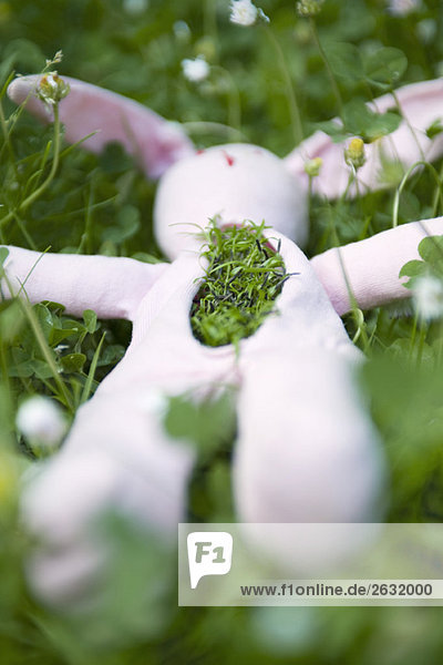 Gefülltes Kaninchen auf dem Boden liegend mit Gras aus der Brust.