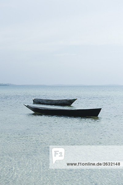 Paar leere Boote nebeneinander schwimmend  Sansibar  Tansania