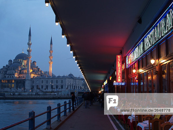 Mosque lit up at dusk  Galata Bridge  New Mosque  Istanbul  Turkey