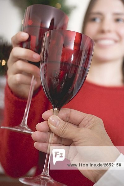 Frauen stossen mit Weingläsern an zu Weihnachten