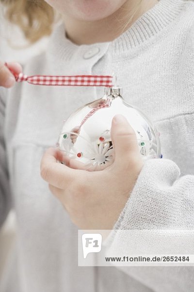Small girl holding Christmas bauble