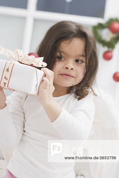Kleines Mädchen hält Weihnachtspäckchen