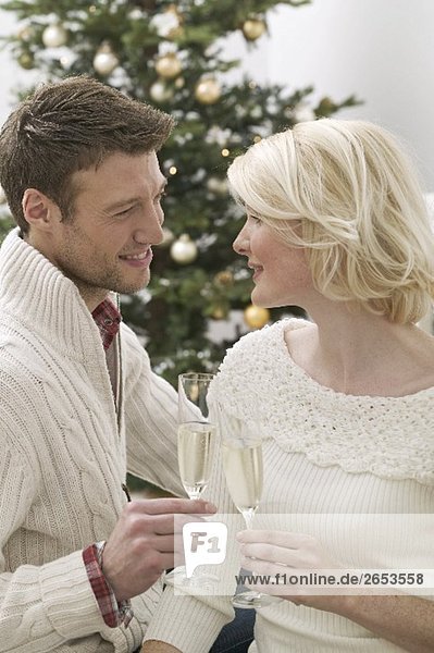 Mann und Frau stossen mit Sektgläsern an zu Weihnachten