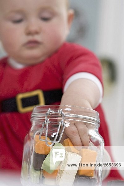 Baby taking sweets out of storage jar