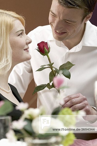 Man giving woman a red rose
