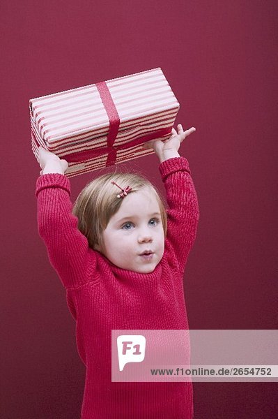 Kleines Mädchen hält Weihnachtspaket