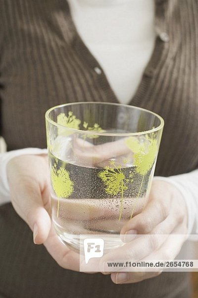 Frau hält Glas Wasser