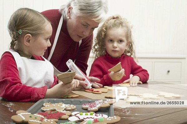 two granddaughters decorating Christmas biscuits
