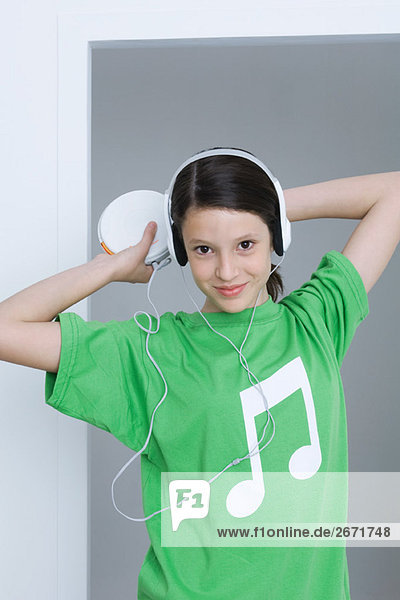 Mädchen hört tragbaren CD-Player  trägt T-Shirt mit musikalischer Note aufgedruckt
