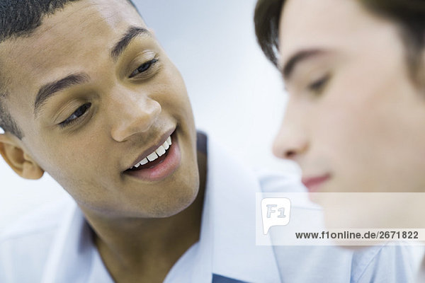 Young professional man chatting with colleague  smiling