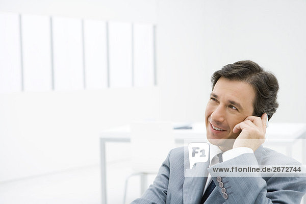 Businessman talking on cell phone  looking away