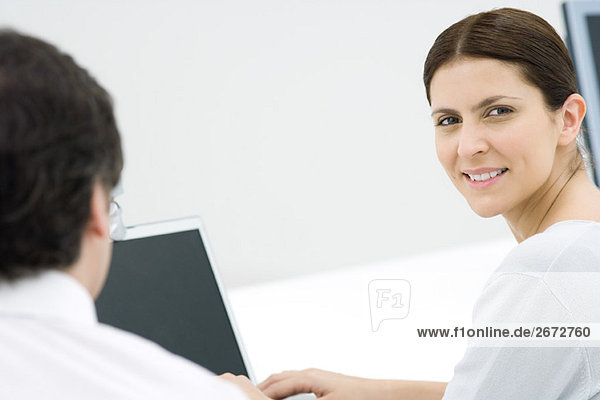 Professional woman in office  smiling over shoulder at camera