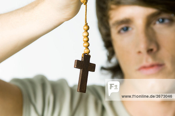 Junger Mann schaut auf das Kreuz  Nahaufnahme